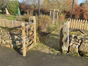 Wide gate leading from car park to upper garden area.