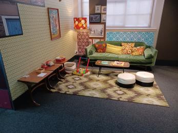 1970s inspired living room area with children's books and toys from the decade