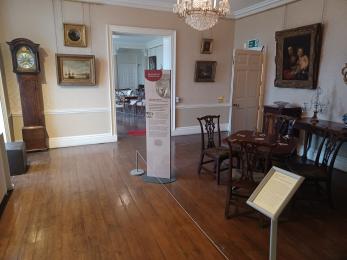 Historic Terrace room on ground floor with clock, card table, paintings and information board