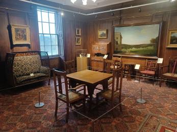 Room with period furniture and paintings on first floor