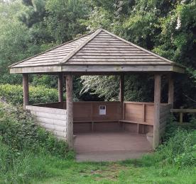 The wooden shelter with bench seating in the picnic area
