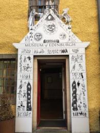 The main entrance with a white archway with the words 'Museum of Edinburgh' in black text over the door.