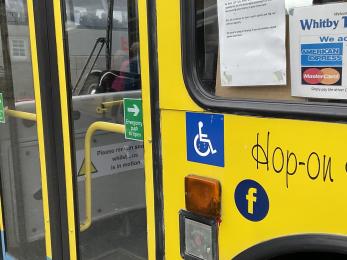 Entry door to Whitby Town Tour bus showing wheelchair accessible logo