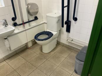 Inside the accessible toilet at the coach station with blue and white contrasting toilet and grab rails