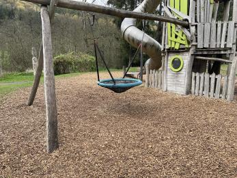 Satellite Swing in Grandfather Oak playground with surface of bark clippings.