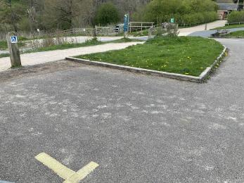 One accessible parking bay and the route leading to the visitor centre main entrance across tarmac and compact gravel.