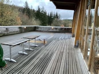 Large, wooden terraced area on the upper floor of the Visitor Centre with views overlooking the forest.