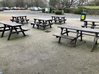 Standard and wheelchair accessible picnic benches on the concrete outside the visitor centre
