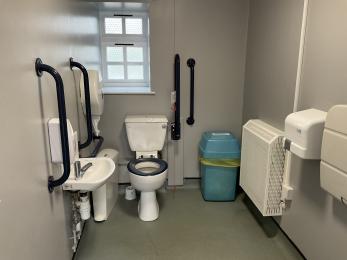 Accessible toilet at the cycle hub showing good visual contrast between the grab rails and walls and between the toilet and seat