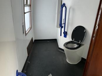 On board accessible toilet facility showing wheelchair transfer space and wall-mounted baby changing facility
