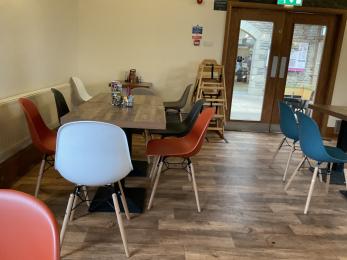 Tables with different coloured chairs in the Park Life Cafe