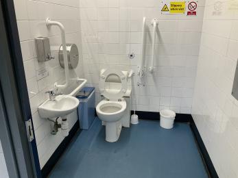 Inside the external visitor centre toilets showing white features against a blue floor with black skirting