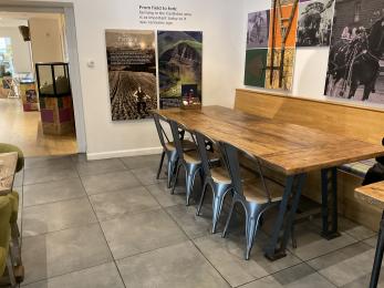 Four metal and wooden chairs, large wooden table with historic images on the wall