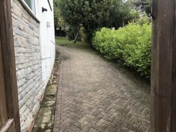 Access to the house back entrance avoiding steps up a slope on block paving