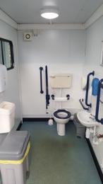 Accessible toilet showing blue handrails