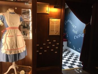 The doorway into Alice in Wonderland, with Alice's dress displayed to the left