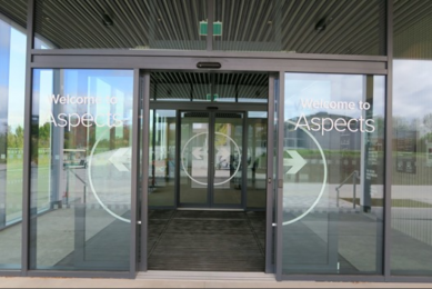 Aspects Building entrance lobby with 2 sets of automatic sliding doors.