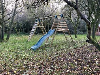 Children’s play area in the orchard on grass surface