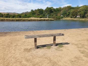 Bench next to meander in south car park. 
