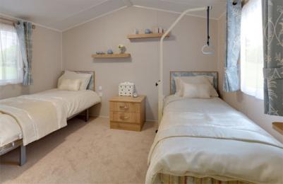 View of main twin bedroom with sliding door and portable helper frame in the caravan holiday home at Blairgowrie Holiday Park