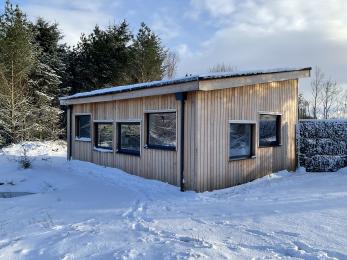 The Nature Hub surrounded by snow in a woodland setting.