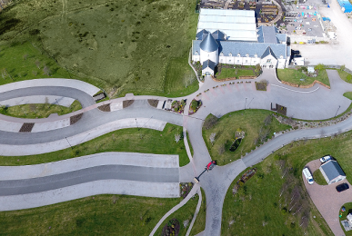 Drone image of three carparks that attach on to The Mains of Drum and paths that lead from them to the entrance. 