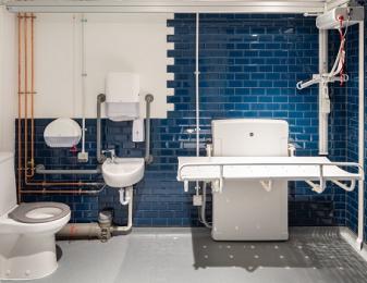 The cloakroom disabled toilet showing toilet, sink, changing bed and overhead hoist