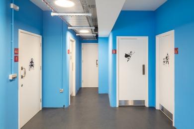 The white toilet doors in the blue cloakroom