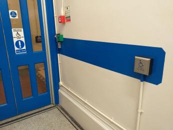 Helping visitors locate the press button to automatically open doors