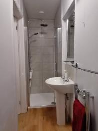Shower with bifold internally opening door. Small (2cm) step up.  Pedastal basin.
