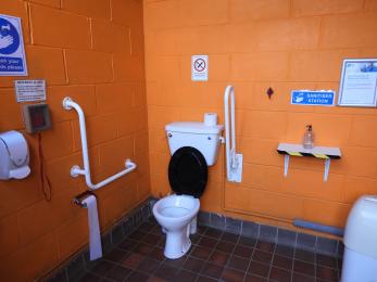 Toilet area showing hand rails both sides