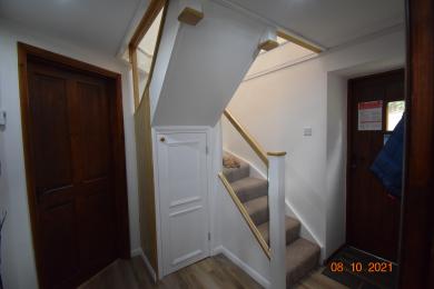 Hallway showing back door, door into ground floor bedroom and staircase to first floor
