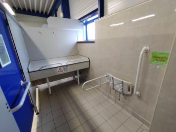 Disabled changing area with changing table, shower seat, hand rails and emergency alarm.