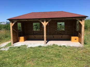 Front view of Education Shelter with access path to the side and grass area in front.
