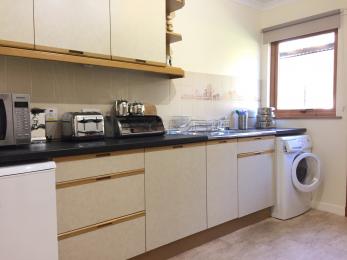 Forestry House Kitchen has normal height surfaces and a front loading washing machine