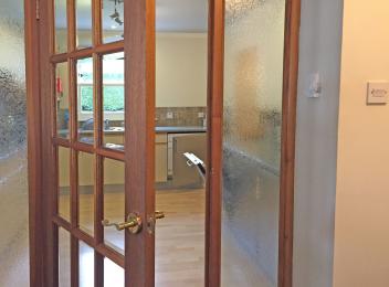 Glass door access to kitchen from Lounge