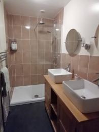 Twin basins with lever taps, access to walk-in shower.  Separate shower chair available