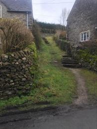 Entrance slope and steps up to the cottage from the road where the residents parking is located. Steps lead to the Kitchen Entra