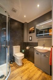 The Grey Suite bathroom showing white fittings with contrasting dark grey walls
