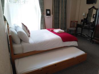 Internal view of ground floor bedroom showing a double bed with a full sized single trundle bed below. 
