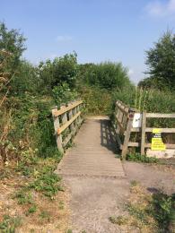 Wooden bridge which connect the car park to the entrance of the reserve at RSPB Greylake