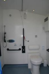 Disabled toilet and shower with emergency pull cord between toilet and shower in red