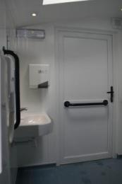View from toilet seat towards sink and door