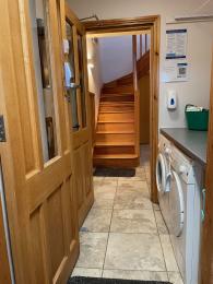 The Byre internal property entrance opening into the utility area and beyond into the hallway