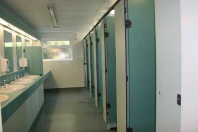 Ladies toilets/showers - doors and partitions contrasting colours.  Disabled toilet has white walls with blue handrails.