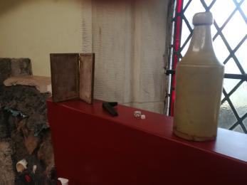 A selection of our handling collection: a Victorian bottle, medieval dice, a Viking anvil, and a Roman wax tablet.