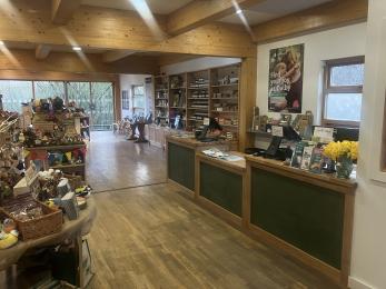 Visitor centre shop with items for sale on display shelving and wide pathway around.