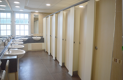 Image of Ladies toilets, showing walkway to cubicles and multiple sinks.