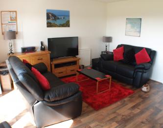 Lounge with two black sofas, coffee table and television