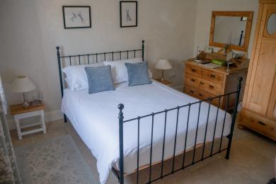 Bedroom including rugs, iron bedstead and linen.